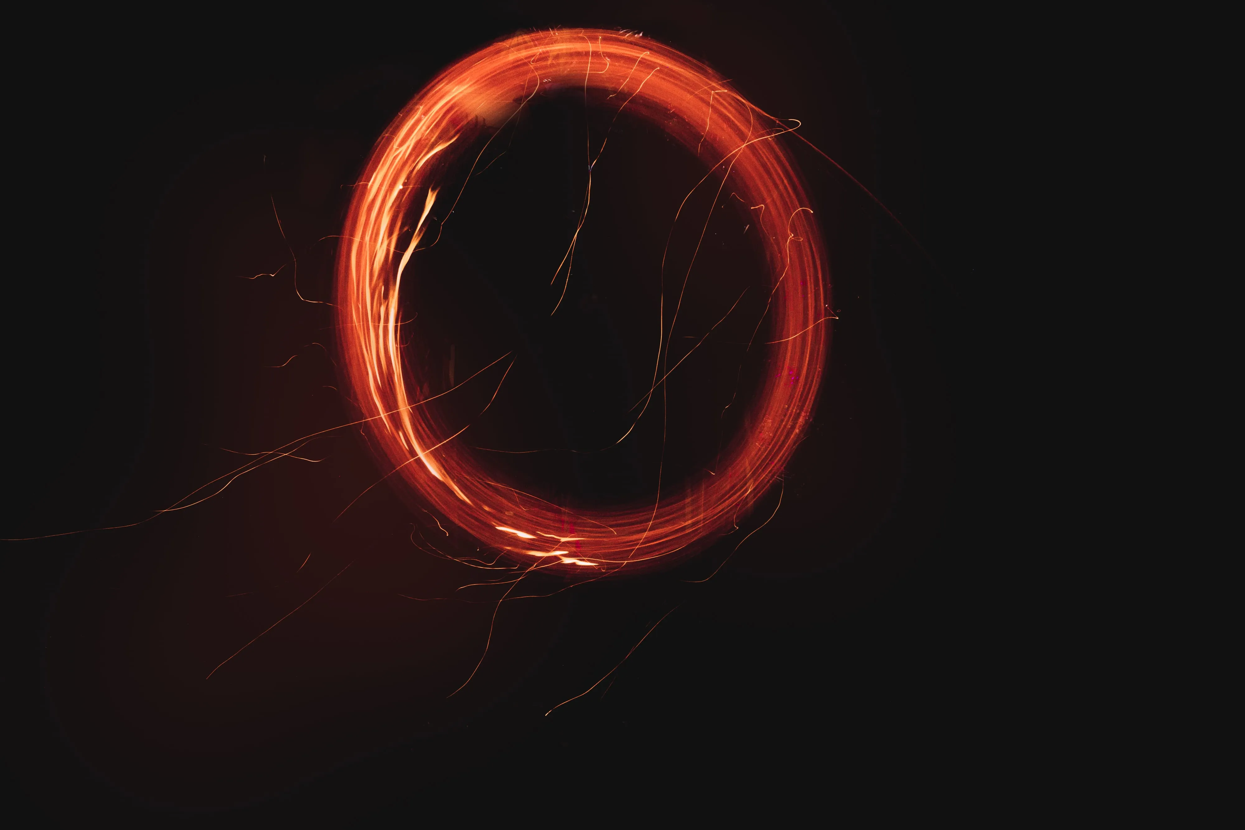 A ring of fire drawn by one long exposure, sparks trailing off it